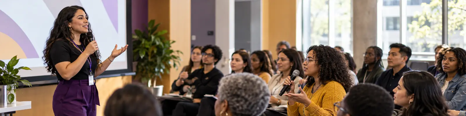 A community educator speaking with a diverse audience during an advocacy event.