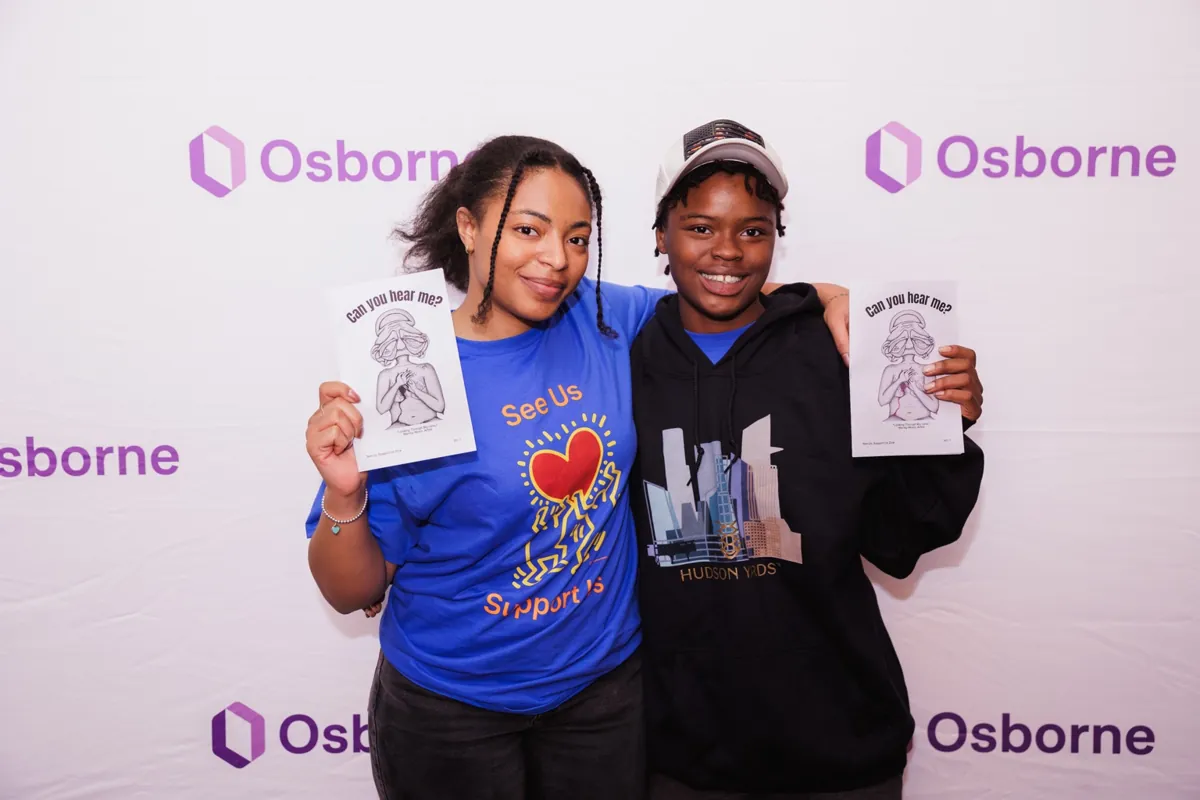 Anyé Young and Lashea Waring hold the inaugural Can You Hear Me? SUSU Youth Team Zine at an Osborne Association event.